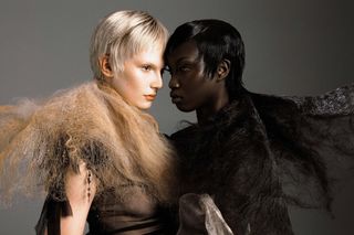 Two models facing each other against a grey background