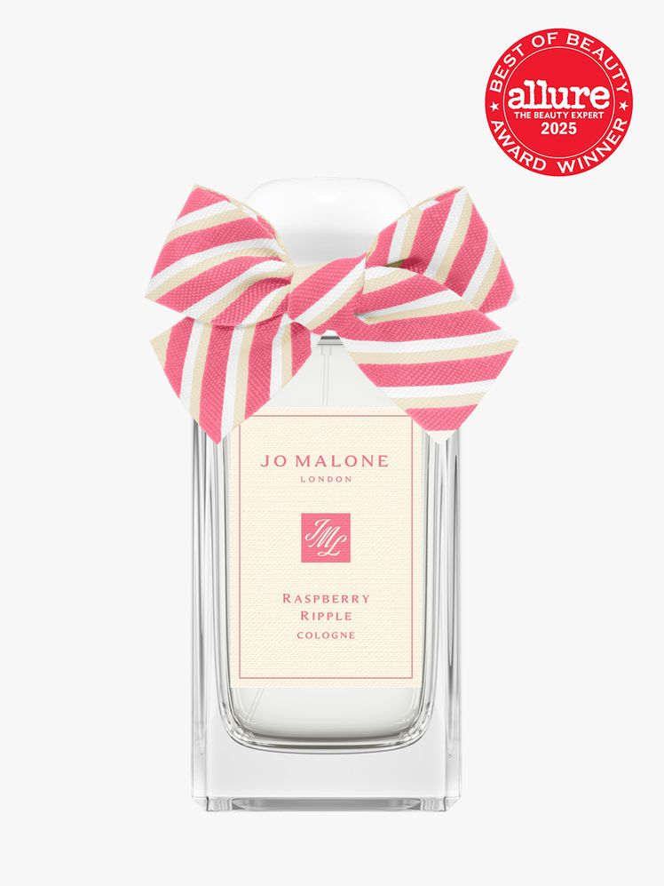 Jo Malone Raspberry Ripple in clear glass bottle with decorative ribbon cap on light gray background with red Allure...