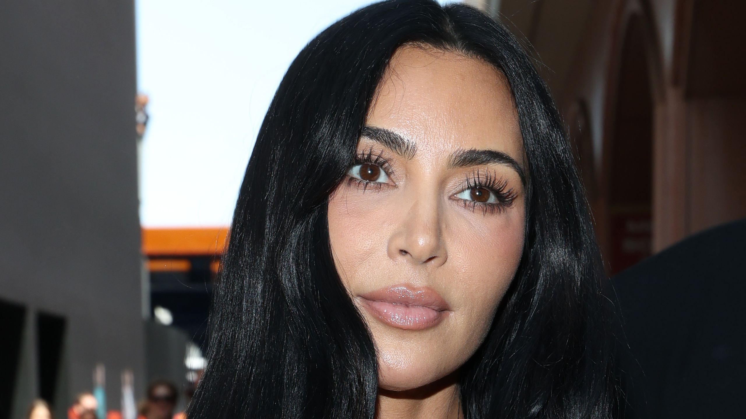 Kim Kardashian appears in Monaco wearing a lace top. Her hair is long and loose.