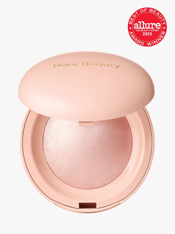 Rare Beauty Positive Light Silky Touch Highlighter in branded peach compact on light gray background with red Allure...