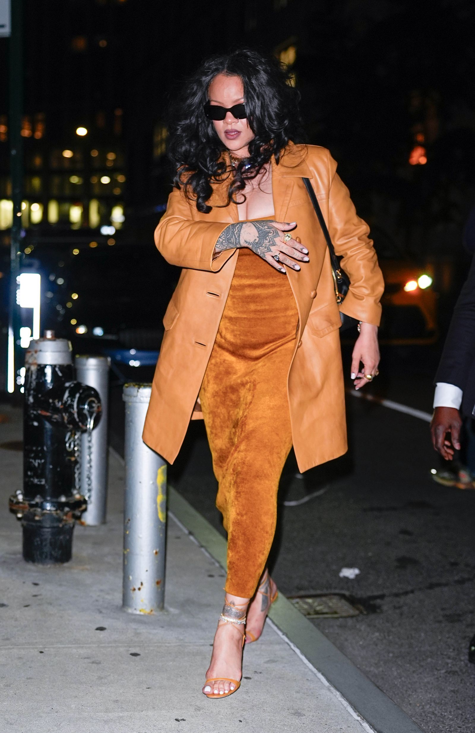 Rihanna walking in NYC wearing a camel leather coat and fuzzy dress